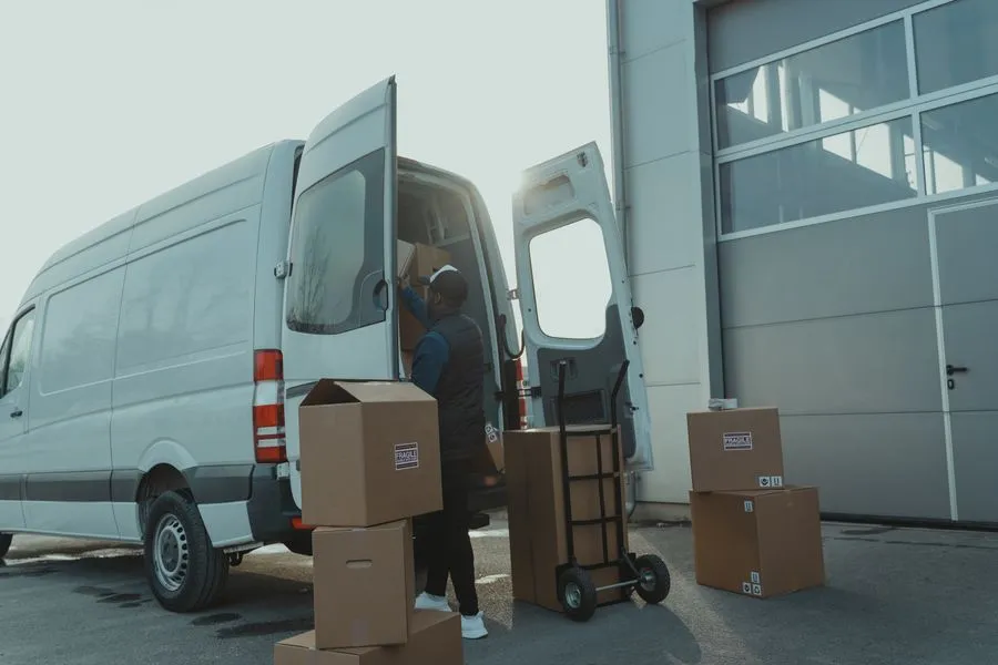 Persona cargando cajas en una camioneta de flete